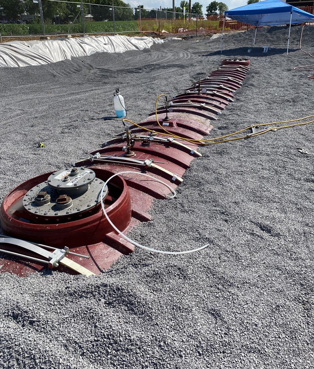 Tank-top fittings exposed after backfill, ready for the sumps